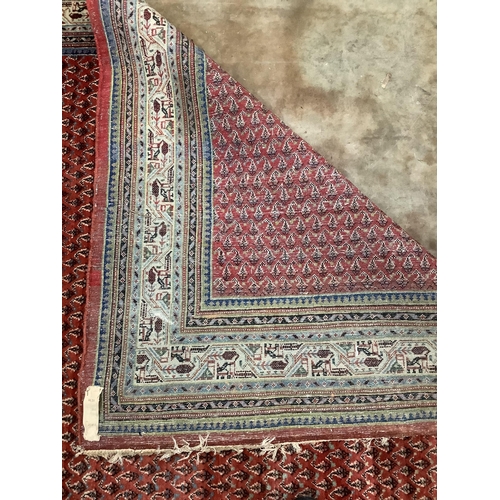 1111 - A rectangular Saraband Hamadan Boteh design rug with repeat central field and mythical animal design... 