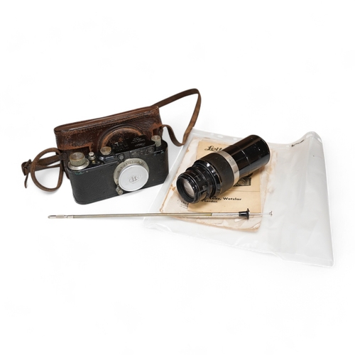 1252 - A Leica Model II camera in leather case, together with an Elmar 4.5/135mm lens, lens table booklet a... 