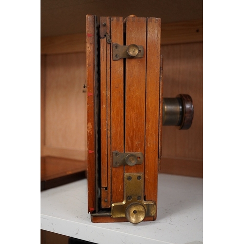 1256 - An early 20th century brass mounted mahogany full plate camera, together with a glass negative holde... 