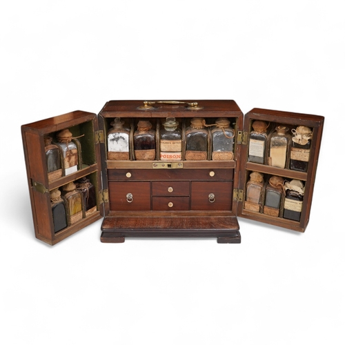 1266 - A 19th century mahogany apothecary cabinet, containing 20 bottles of various medicinal compounds and... 