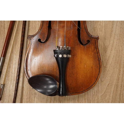 1288 - A late 19th century German violin, body 35cm long, and two bows. Condition - poor to fair.