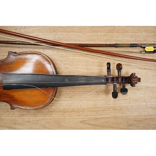 1288 - A late 19th century German violin, body 35cm long, and two bows. Condition - poor to fair.