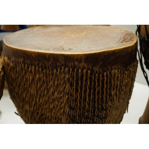 1294 - Five African drums; a Djembe, 50cm high, together with four others, including a pottery triple drum,... 