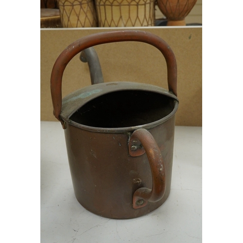 1414 - A copper watering can and a helmet coal scuttle, watering can 40cm high. Condition - interior of coa... 