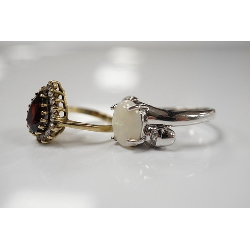 1920 - A modern 9ct white gold and single stone cabochon white opal set ring, size N and a 9ct gold, garnet... 