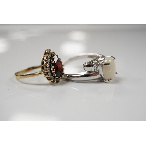 1920 - A modern 9ct white gold and single stone cabochon white opal set ring, size N and a 9ct gold, garnet... 