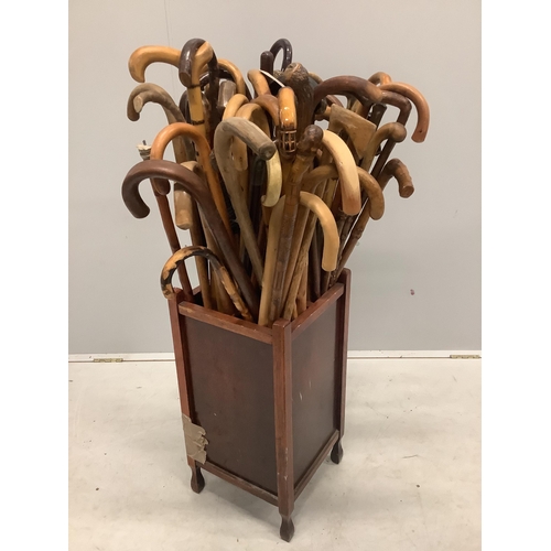 31 - A large collection of assorted walking and shooting sticks in four division stick stand. Condition -... 