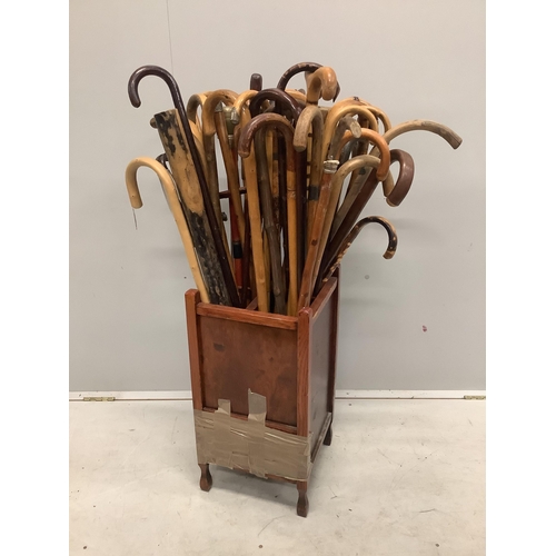 31 - A large collection of assorted walking and shooting sticks in four division stick stand. Condition -... 