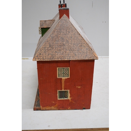 332 - A 1920s/30s commercially produced dolls house, possibly by Tri-ang, of plywood construction, overlai... 