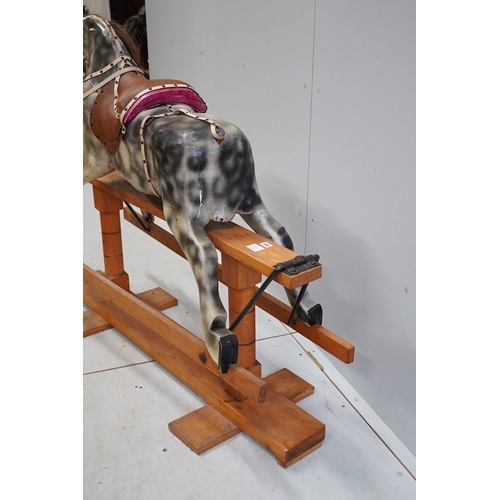 340 - An early 20th century dapple grey rocking horse, on later trestle base, length 132cm. Condition - fa... 