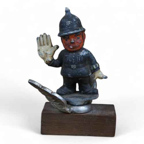 390 - A cold painted cast aluminium car mascot in the form of a caricature of a policeman on associated ch... 