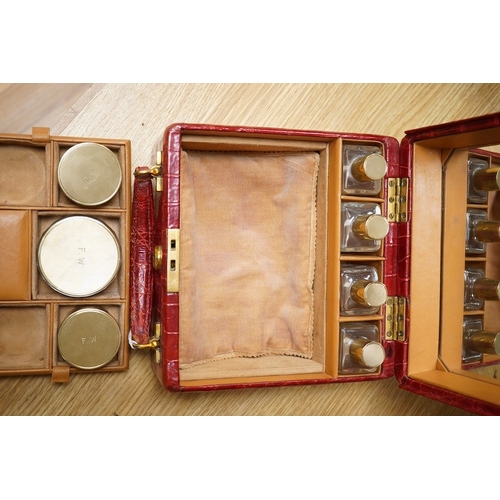 426 - A red stained crocodile skin two layer vanity case, fitted with brass topped bottles and pots, case ... 