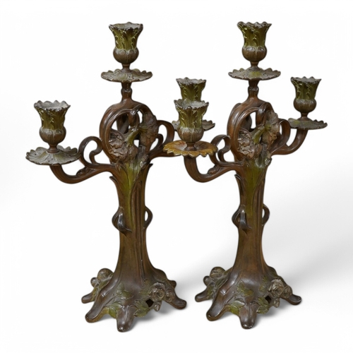 428 - A pair of French patinated spelter floral painted Art Nouveau two branch, three light candelabra, 40... 