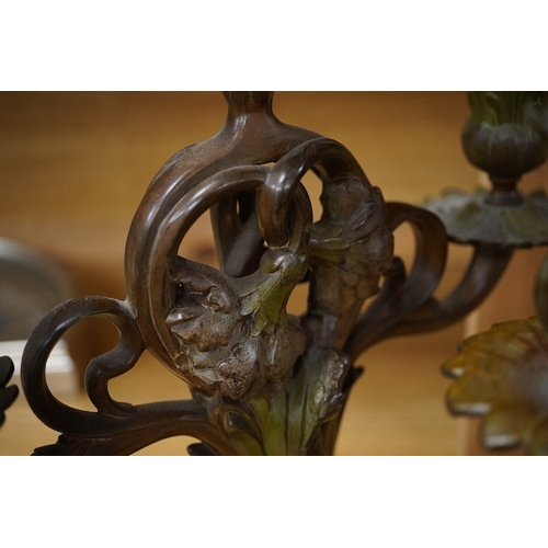 428 - A pair of French patinated spelter floral painted Art Nouveau two branch, three light candelabra, 40... 