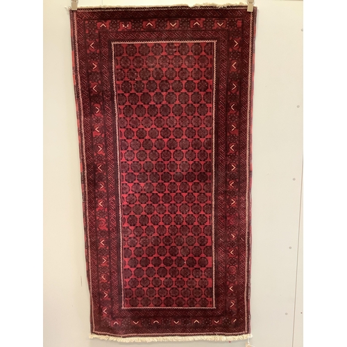 43 - A Belouch red ground rug, 200 x 103cm. Condition - fair