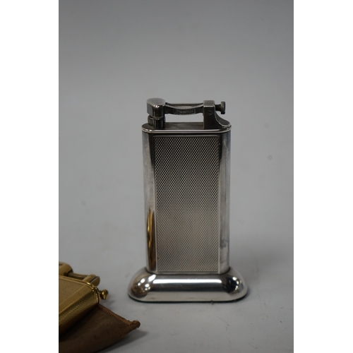 530 - Two Dunhill lighters to include a plated table lighter, largest 10cm high. Condition - fair to good,... 