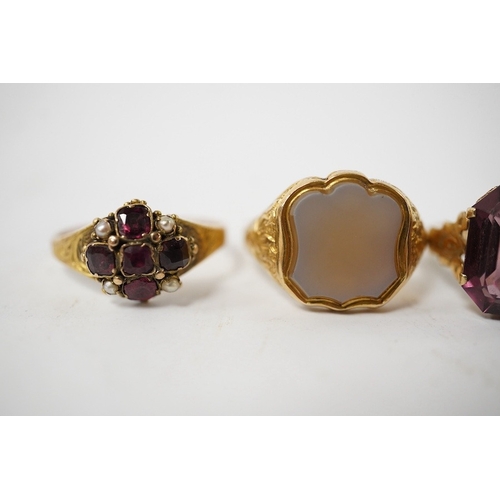 912 - A group of four rings, comprising: a chalcedony signet ring with engraved floral shoulders, size L, ... 