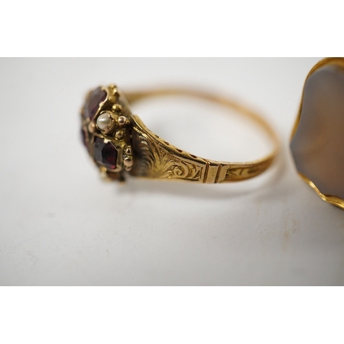 912 - A group of four rings, comprising: a chalcedony signet ring with engraved floral shoulders, size L, ... 