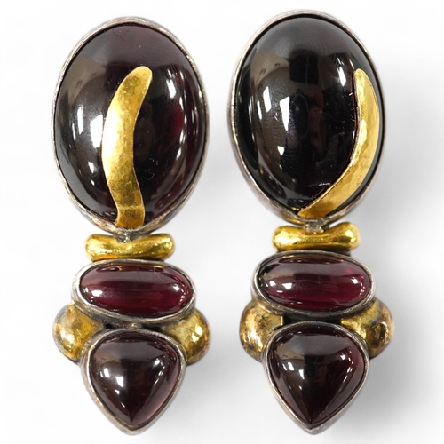 918 - A pair of modern yellow and white metal mounted three stone oval cabochon garnet set drop earrings, ... 