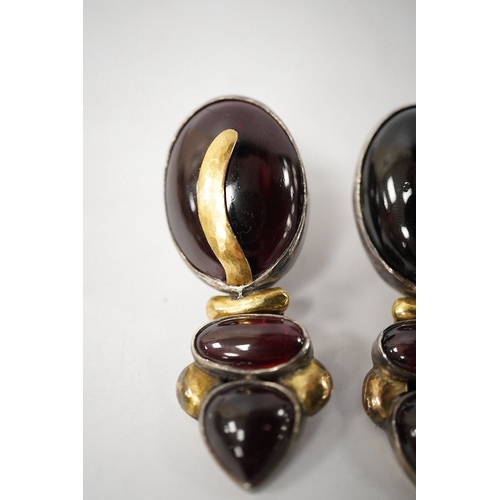 918 - A pair of modern yellow and white metal mounted three stone oval cabochon garnet set drop earrings, ... 