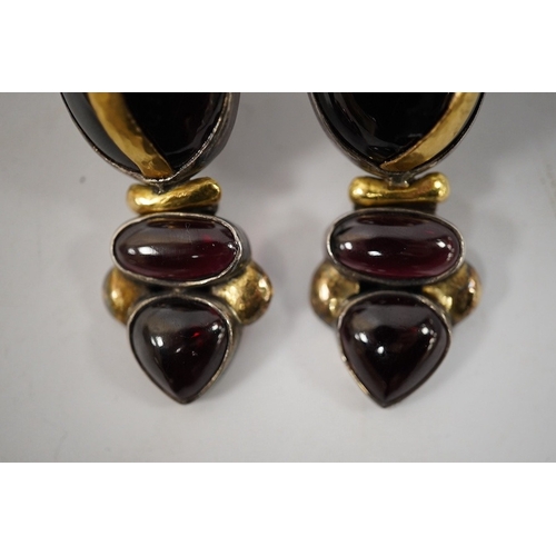 918 - A pair of modern yellow and white metal mounted three stone oval cabochon garnet set drop earrings, ... 