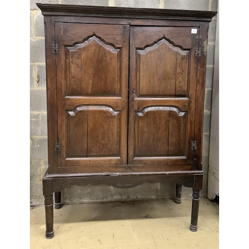 1016 - A mid 18th century carved oak cupboard, on associated stand, a.f., width 130cm, depth 55cm, height 1... 