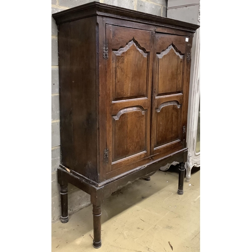 1016 - A mid 18th century carved oak cupboard, on associated stand, a.f., width 130cm, depth 55cm, height 1... 