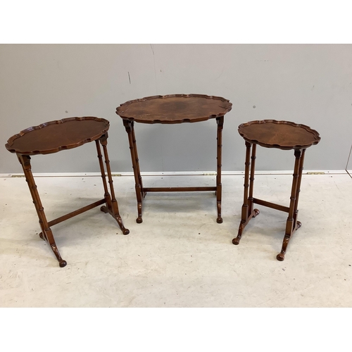 1084 - A nest of three burr walnut oval tea tables, width 56cm, depth 38cm, height 62cm. Condition - fair... 