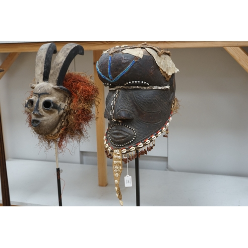 1310 - An African Kuba helmet mask and another horned mask, both on stands & one spare. Condition - helmet ... 