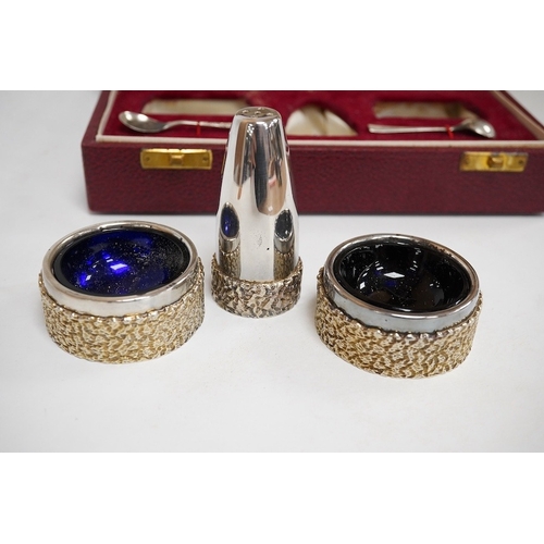 1845 - A cased Elizabeth II parcel gilt silver three piece cruet set, with textured band and two matching s... 