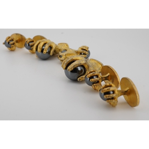 1902 - A modern gilt sterling and hematite set six piece dress stud set, modelled as a hand grasping a sphe... 