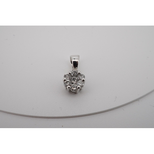 1934 - A modern 9kt white metal and seven stone diamond set circular cluster pendant, total diamond weight ... 