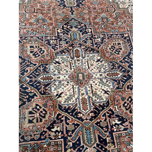 117 - An antique Heriz brick red ground carpet, 350 x 274cm. Condition - fair