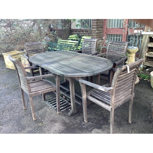 189 - A teak extending garden table, width 180cm, depth 100cm, height 75cm, and five elbow chairs. Conditi... 