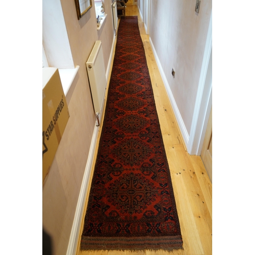 1106 - A large Pakistani Bokhara motif hand-knotted wool red ground runner, approx. 950 x 72cm. Condition -... 