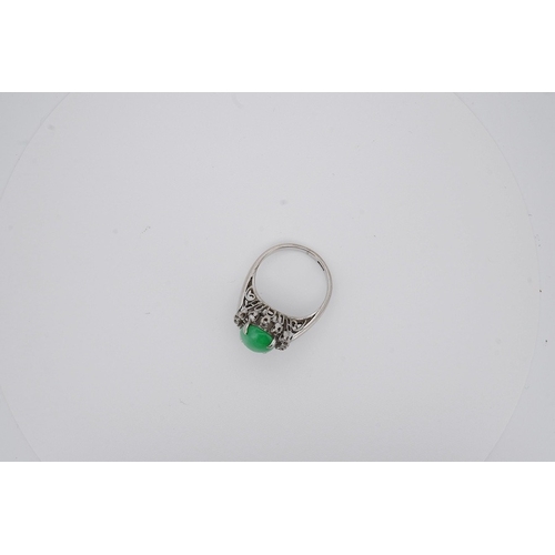 1928 - A white metal and cabochon jade set ring, with round cut diamond set border, size N, gross weight 5.... 