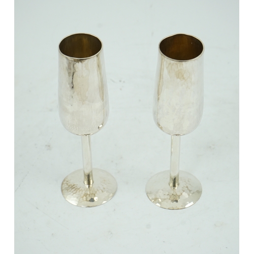 104 - A pair of Elizabeth II planished silver champagne flutes, by Pruden & Smith, on planished domed foot... 