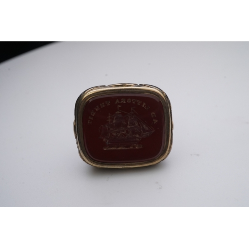 181 - A collection of jewels, comprising: a carnelian fob seal engraved with a ship and the motto 'AD LITT... 