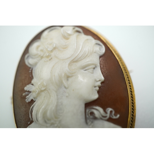 188 - Three shell cameo brooches, 20th century comprising: one depicting a young girl holding a baby goat ... 