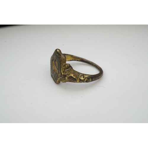 192 - A Tudor bronze signet ring, England, 16th century, the central hexagonal bezel carved with a bird wi... 