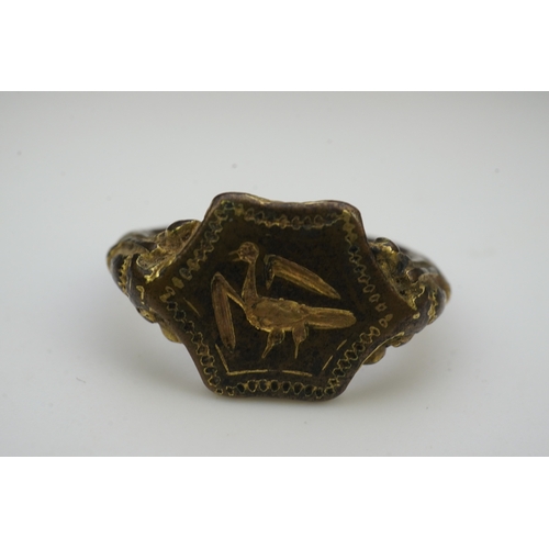 192 - A Tudor bronze signet ring, England, 16th century, the central hexagonal bezel carved with a bird wi... 