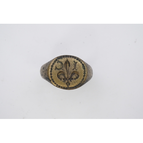 193 - A bronze signet ring, France, 15th/16th century, the circular central panel engraved with a fleur-de... 