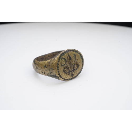 193 - A bronze signet ring, France, 15th/16th century, the circular central panel engraved with a fleur-de... 