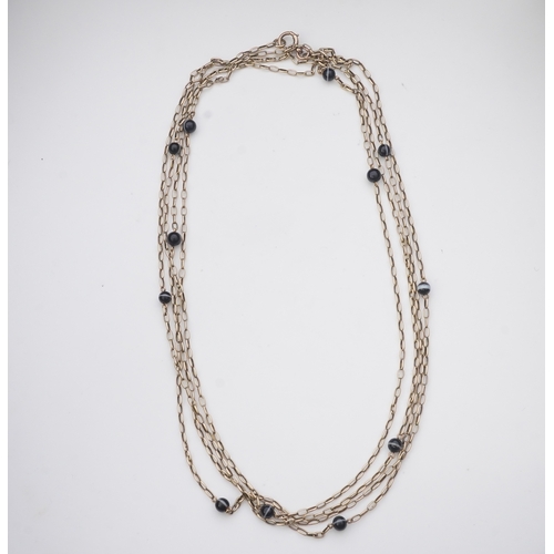 204 - An elegant onyx longchain necklace, early 20th century, composed of elongated belcher linking in gol... 