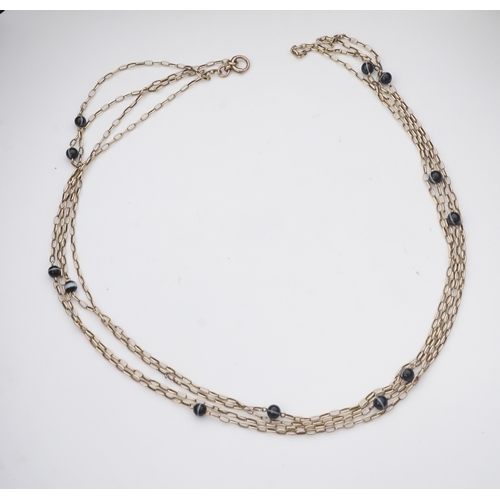 204 - An elegant onyx longchain necklace, early 20th century, composed of elongated belcher linking in gol... 