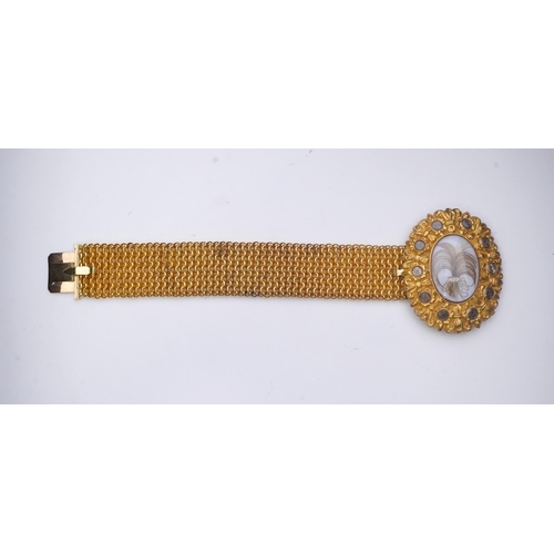 212 - A fine sentimental Georgian gold and hairwork bracelet, 1820s, the oval clasp centring on a glazed c... 