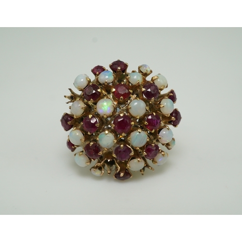 220 - A ruby and opal cocktail ring, mid 20th century, designed as a bombé cluster of circular-cut rubies ... 