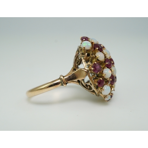 220 - A ruby and opal cocktail ring, mid 20th century, designed as a bombé cluster of circular-cut rubies ... 