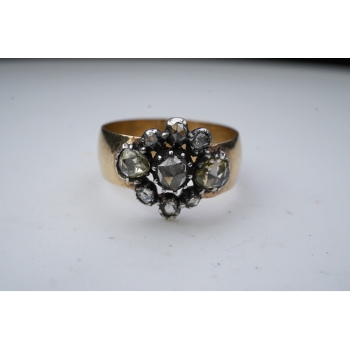 222 - A gold and diamond ring, centering on a cluster of rose-cut diamonds mounted in silver, to a wide 9c... 