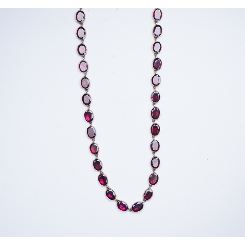 226 - A garnet rivière necklace, circa 1970, designed in the Georgian style, composed of links set with fl... 